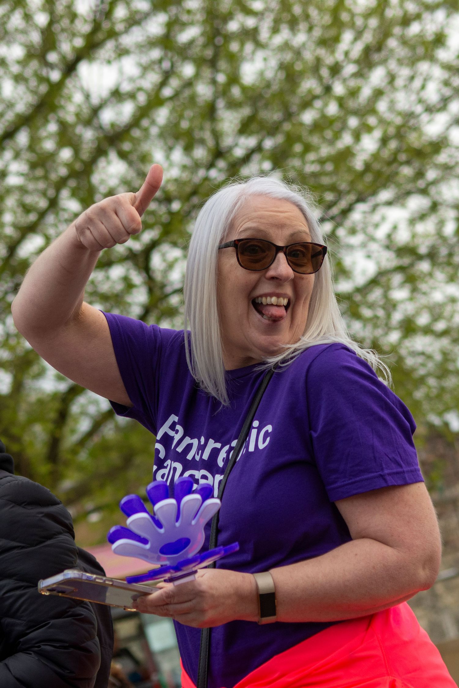 Woman in purple Pancreatic Cancer UK shirt gives thumbs up at the London Marathon