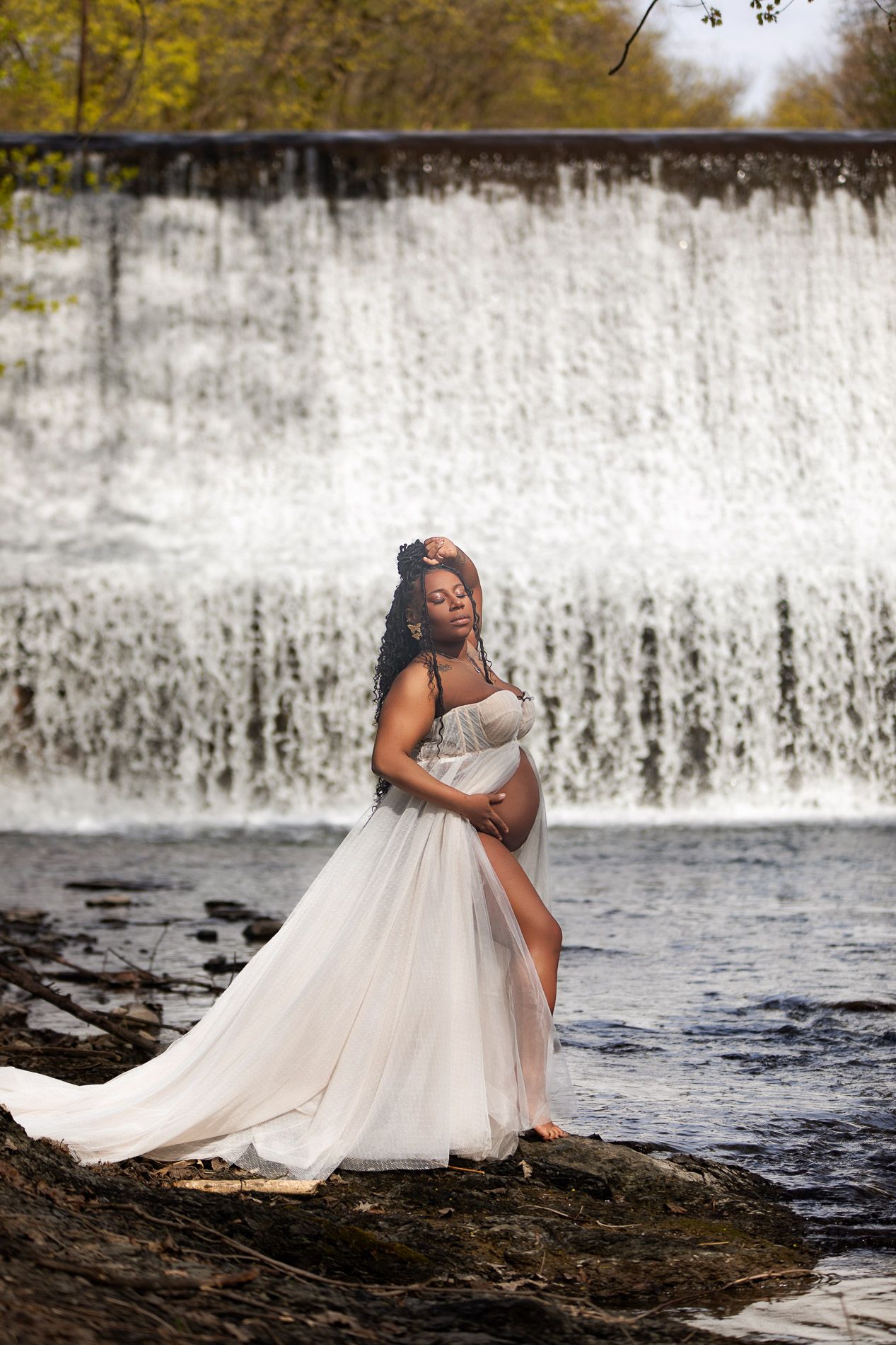 pregnant woman posing for maternity photography in beach waterfall boardwalk with husband and children upstate new york albany troy watervliet burden falls