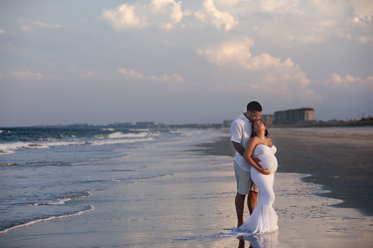 pregnant woman posing for maternity photography in beach boardwalk with husband and children