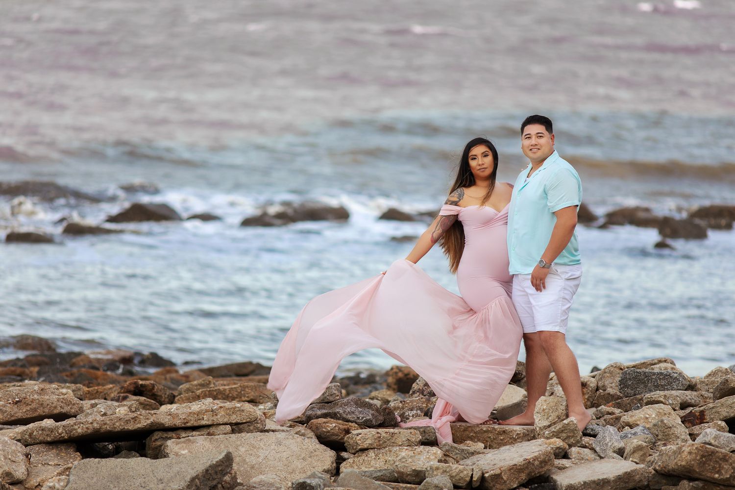 pregnant woman posing for maternity photography in beach boardwalk with husband and children