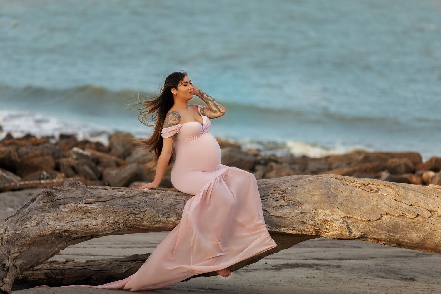 pregnant woman posing for maternity photography in beach boardwalk with husband and children