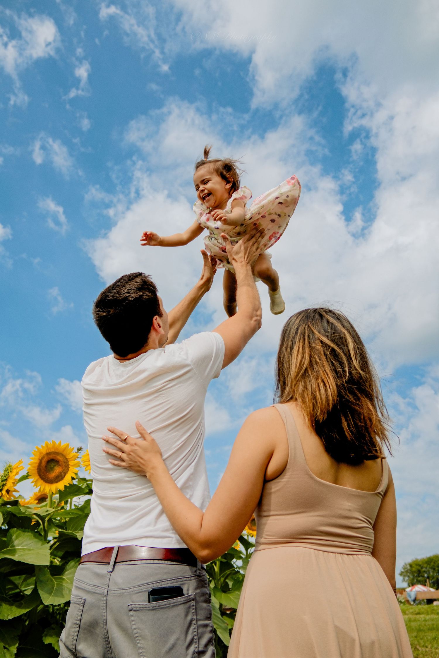 Family standing in a blooming sunflower field at Pingle's Farm Market in Oshawa