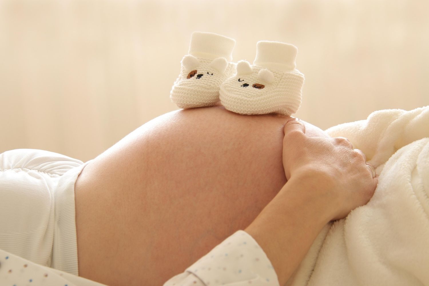 Femme enceinte allongée - Chausson - Bien-être - Grossesse - Ventre
