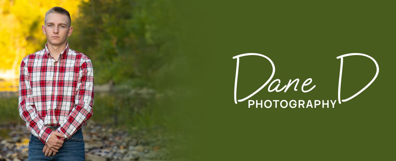 Teen boy in red plaid shirt posing outdoors by a rocky riverbank, Dane D Photography.
