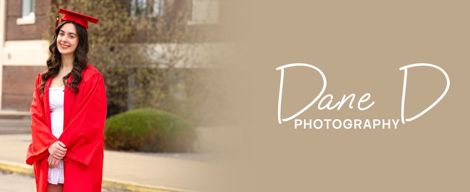 Young woman in red graduation cap and gown posing outdoors, Dane D Photography portrait.