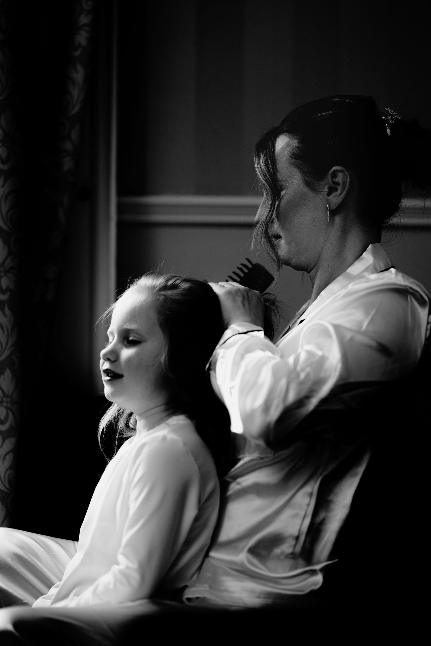 Bride at her winter wedding doing her daughters hair.