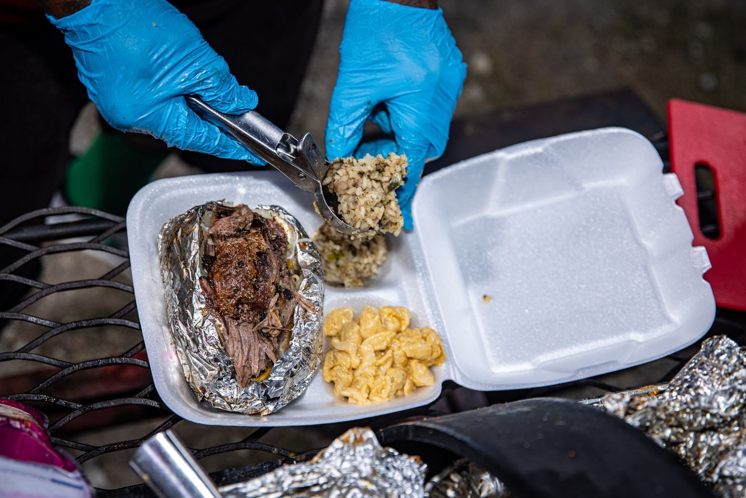 Brisket and sides being plated for a catering order