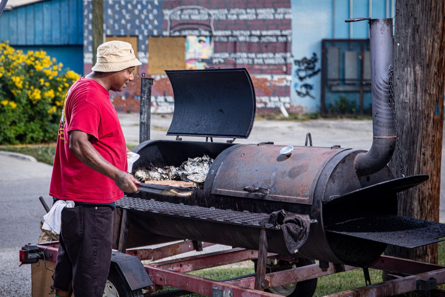 Caterer working a large outdoor smoker at Mike's Catering