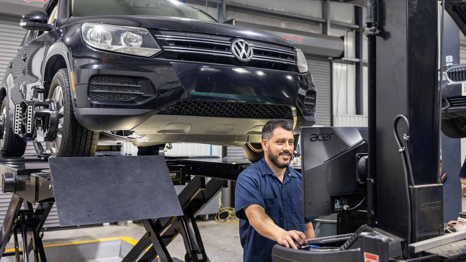 Technician working on a vehicle in a clean service bay at ABR Houston