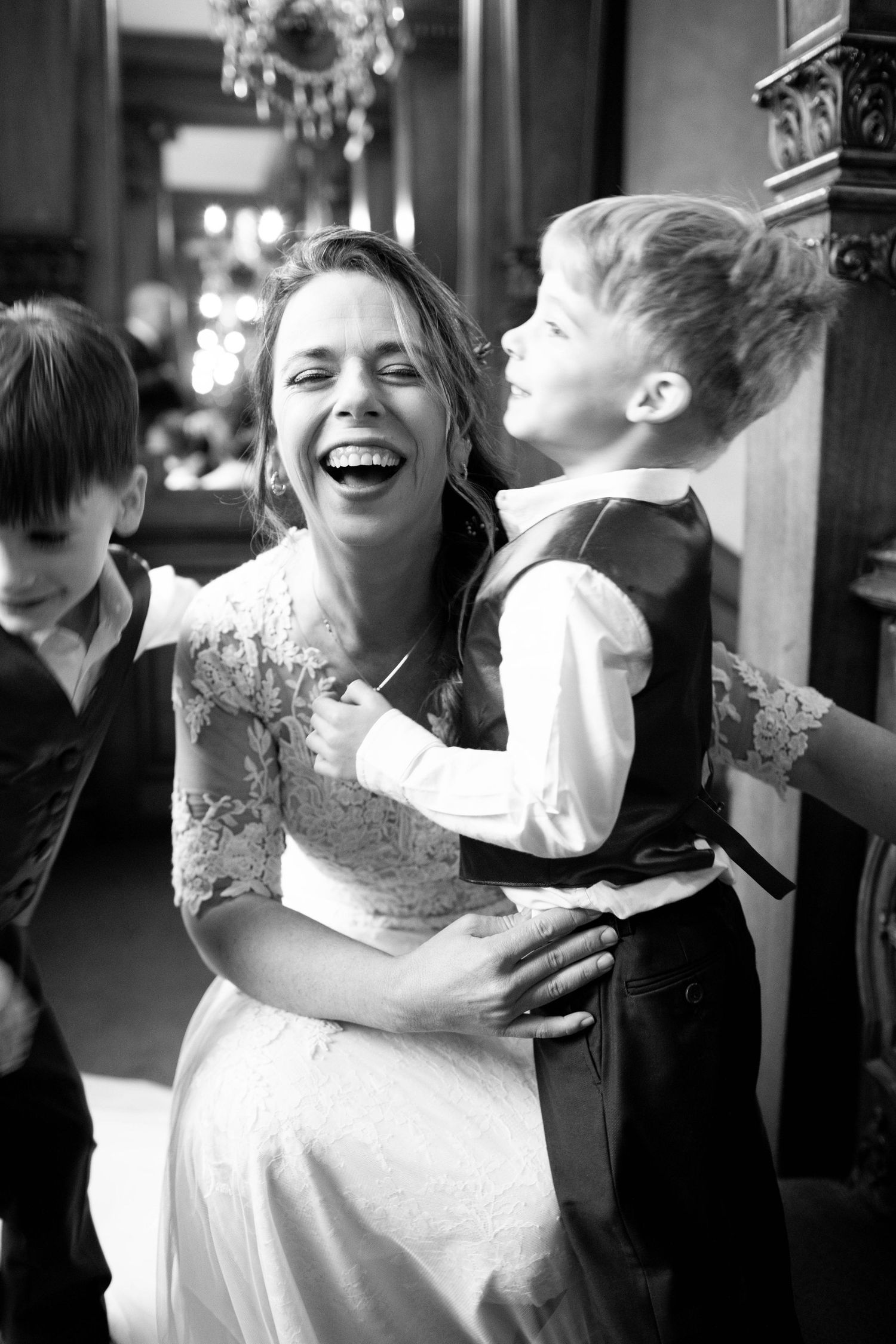 A heartwarming black and white moment between a bride in lace and a young child.