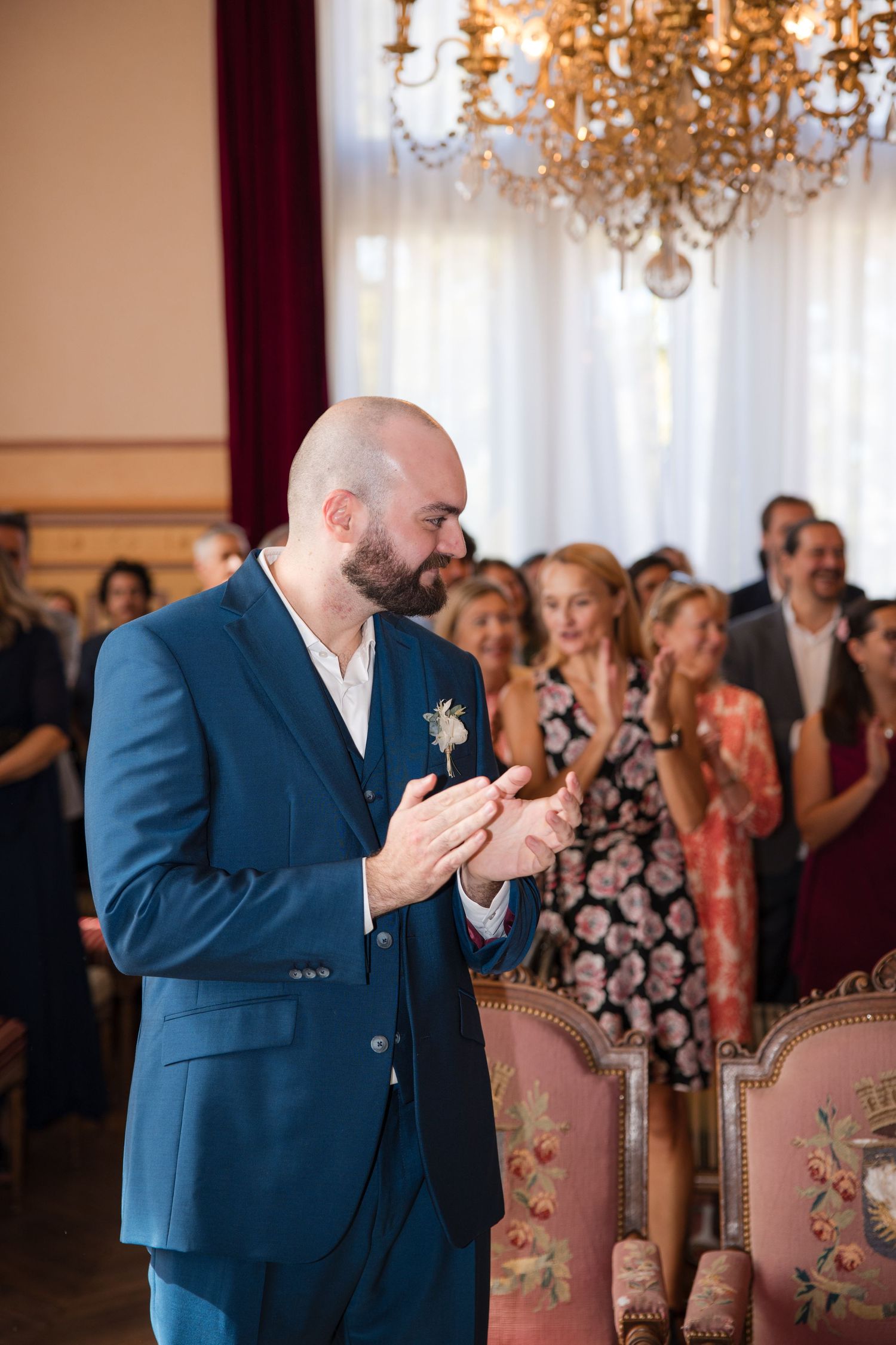 Groom applauding the bride alongside wedding guests during the civil ceremony at Montrouge town hall.
