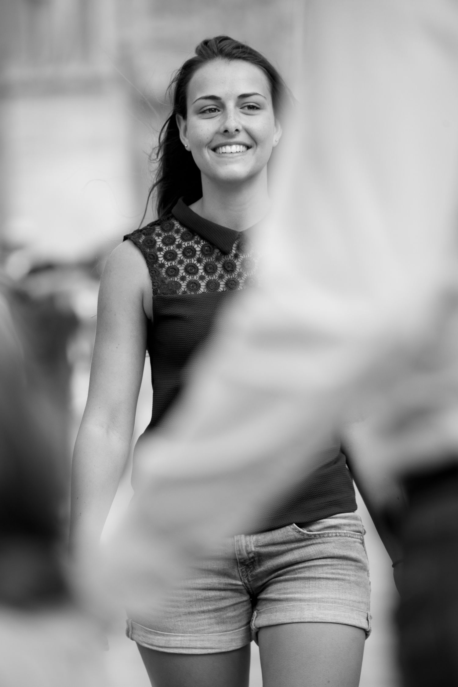 Black and white portrait of a smiling woman on the square outside Notre-Dame Cathedral in Paris.