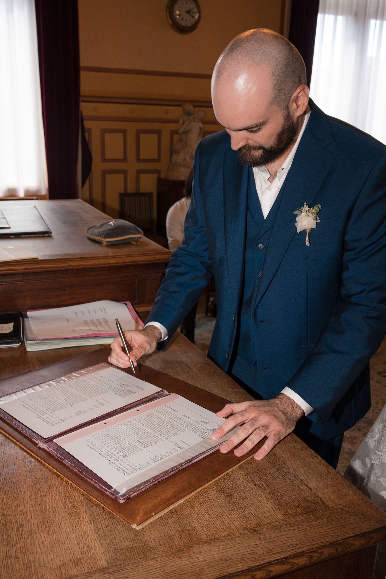 Groom signing the marriage register during the civil wedding ceremony at Montrouge town hall.