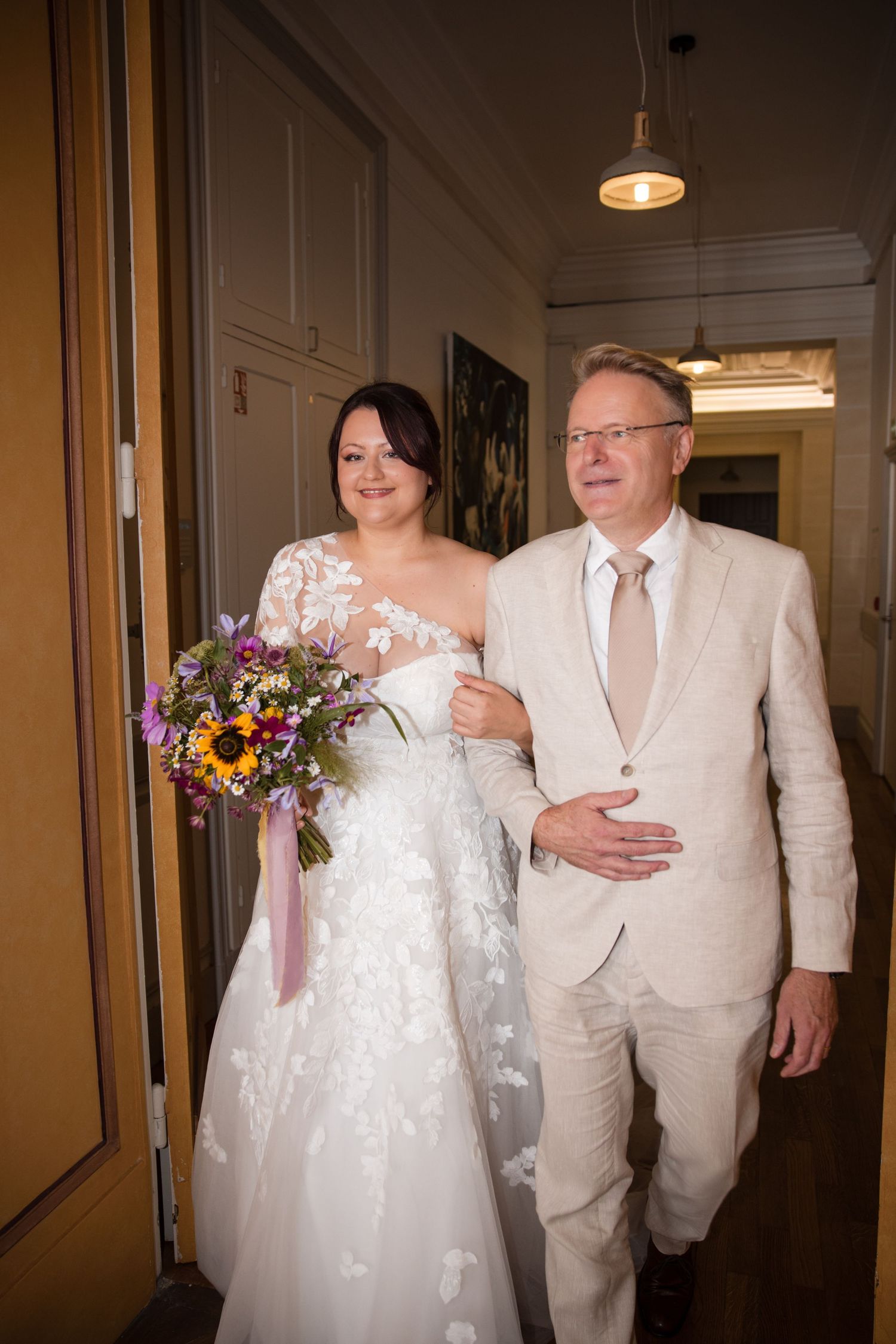 Bride arriving arm in arm with her father-in-law for her civil wedding ceremony at Montrouge town hall.