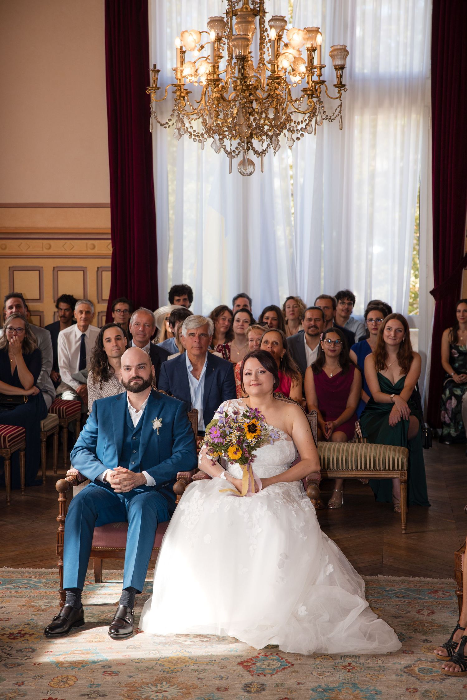 Bride and groom seated before their guests during their civil wedding ceremony at Montrouge town hall.