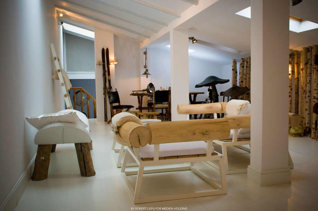 Elegant minimalist living room with white furniture, wooden accents, and white columns in a modern interior design.