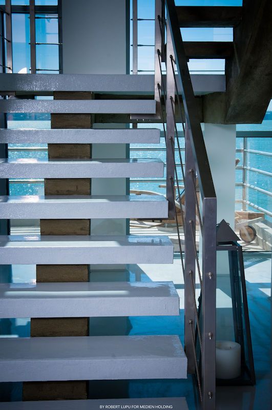 Modern open staircase with white and wood steps, metal railings in a contemporary home.