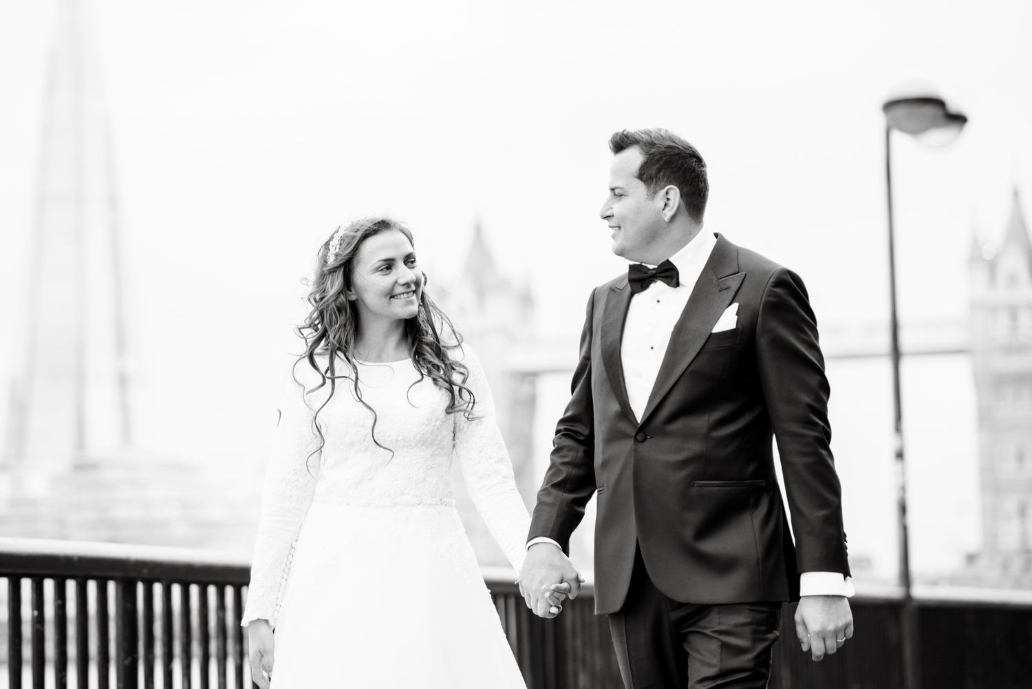 Bride and groom walking hand in hand with The Shard in the background in London.