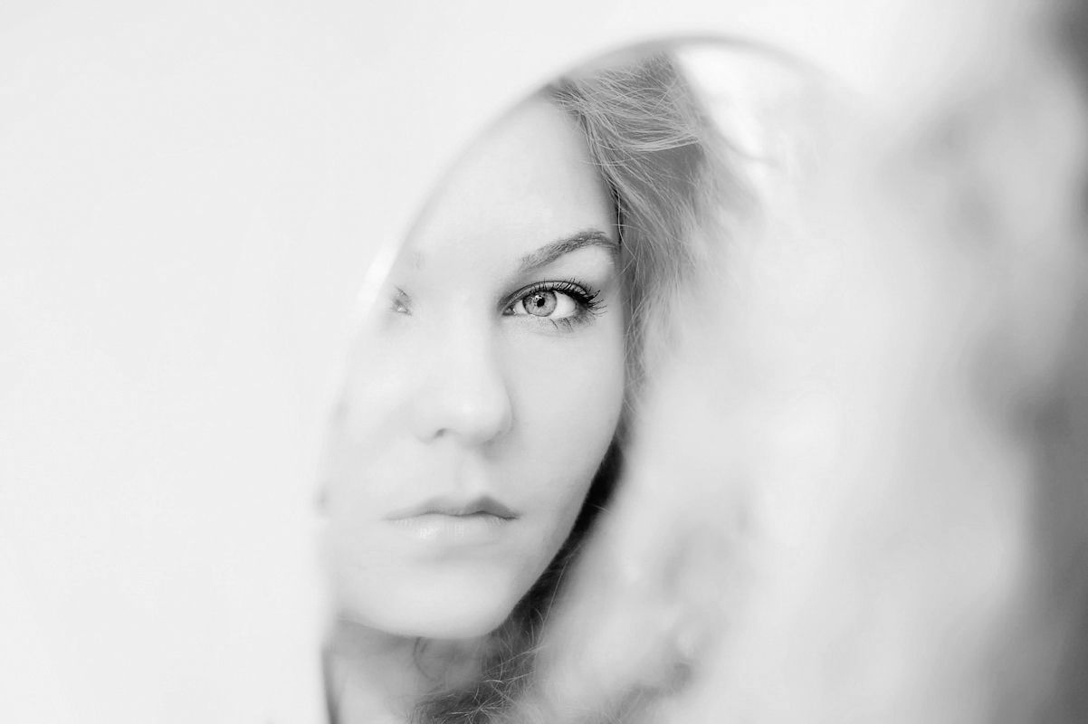 Soft focus black and white close-up portrait of a blonde woman with dreamy double exposure effect.