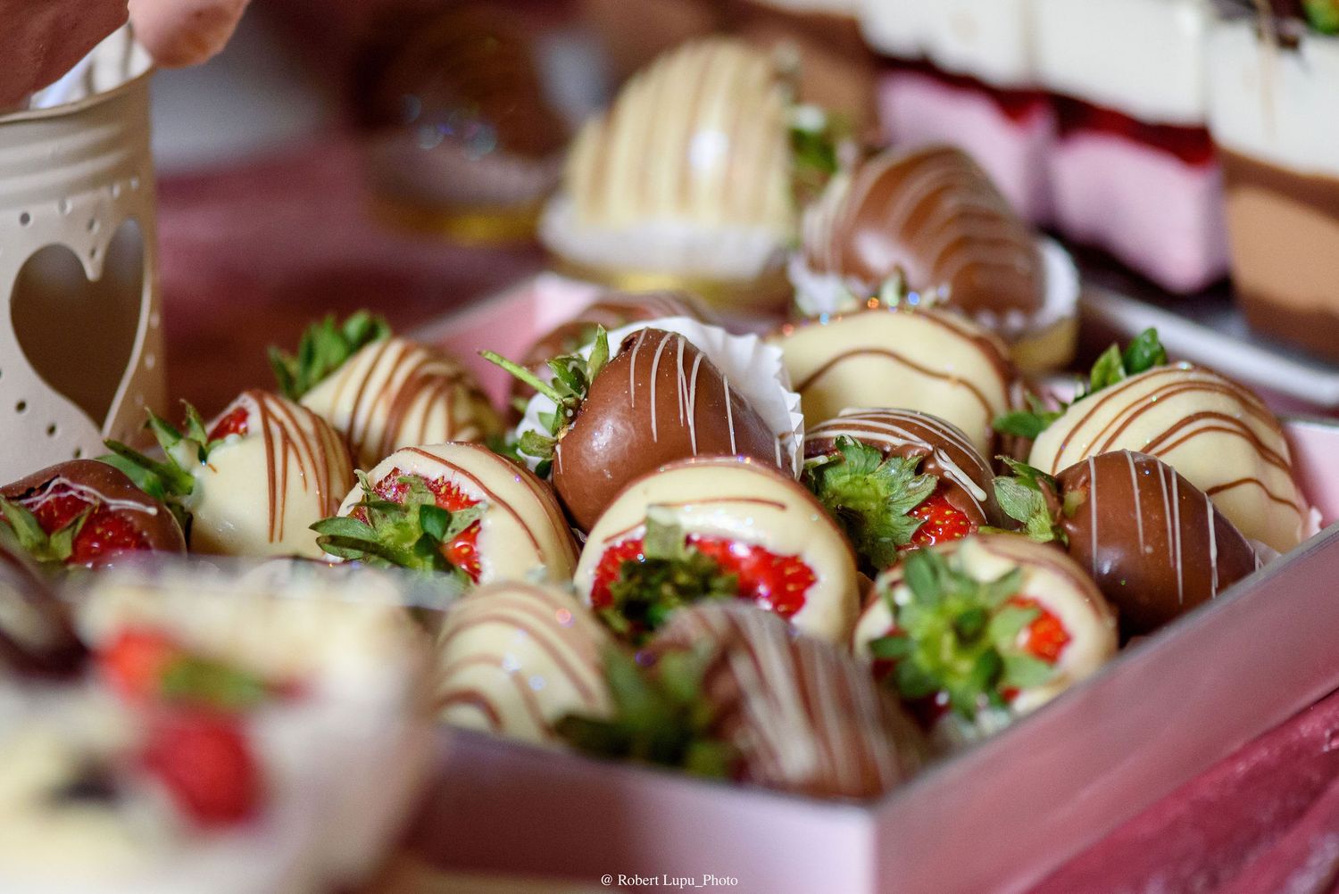 Chocolate-dipped strawberries with white and dark drizzle in a gift box.