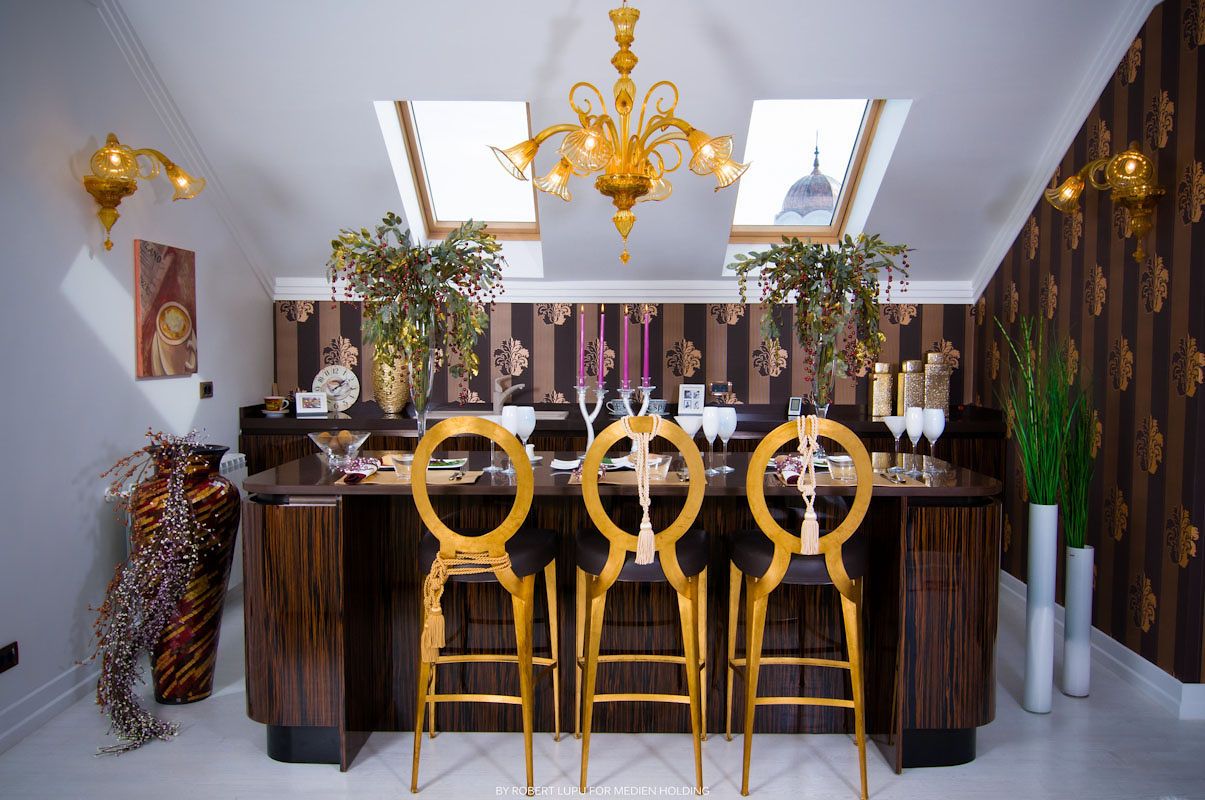 Elegant bar area with gold bar stools, chandelier, and ornate wood paneling in a luxury interior.