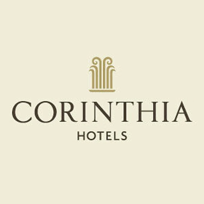 Corinthia Hotels official logo with ornate golden pillar emblem and classic serif font on warm ivory background.