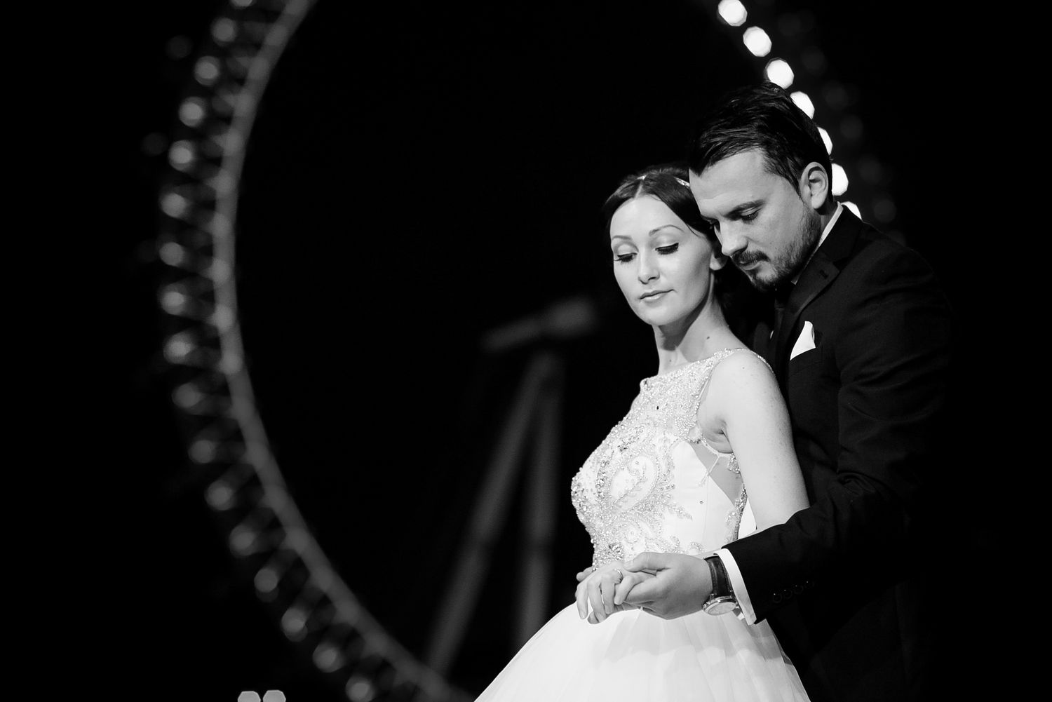 Couple shares intimate moment with London Eye backdrop in elegant black and white wedding photo.