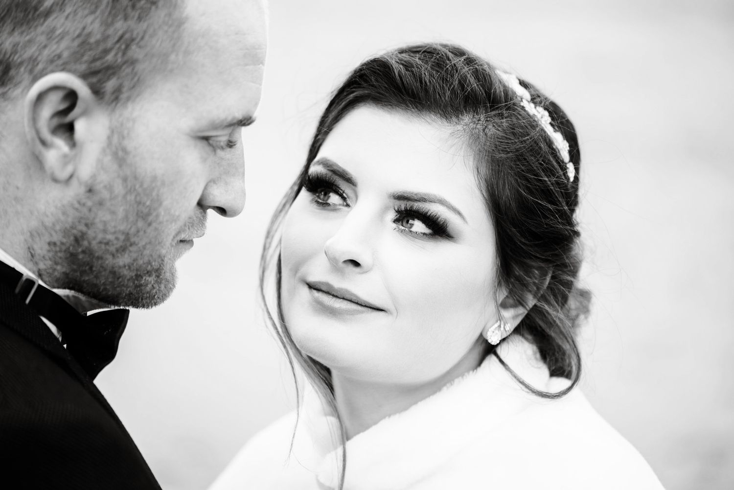 Black and white portrait of bride and groom in close romantic pose on wedding day.