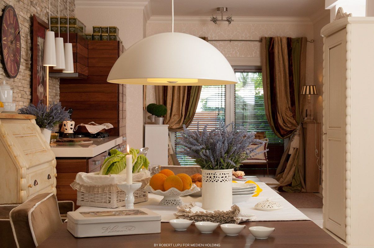 Bright kitchen dining area with white pendant lamp, fresh fruits, and view of lavender garden.