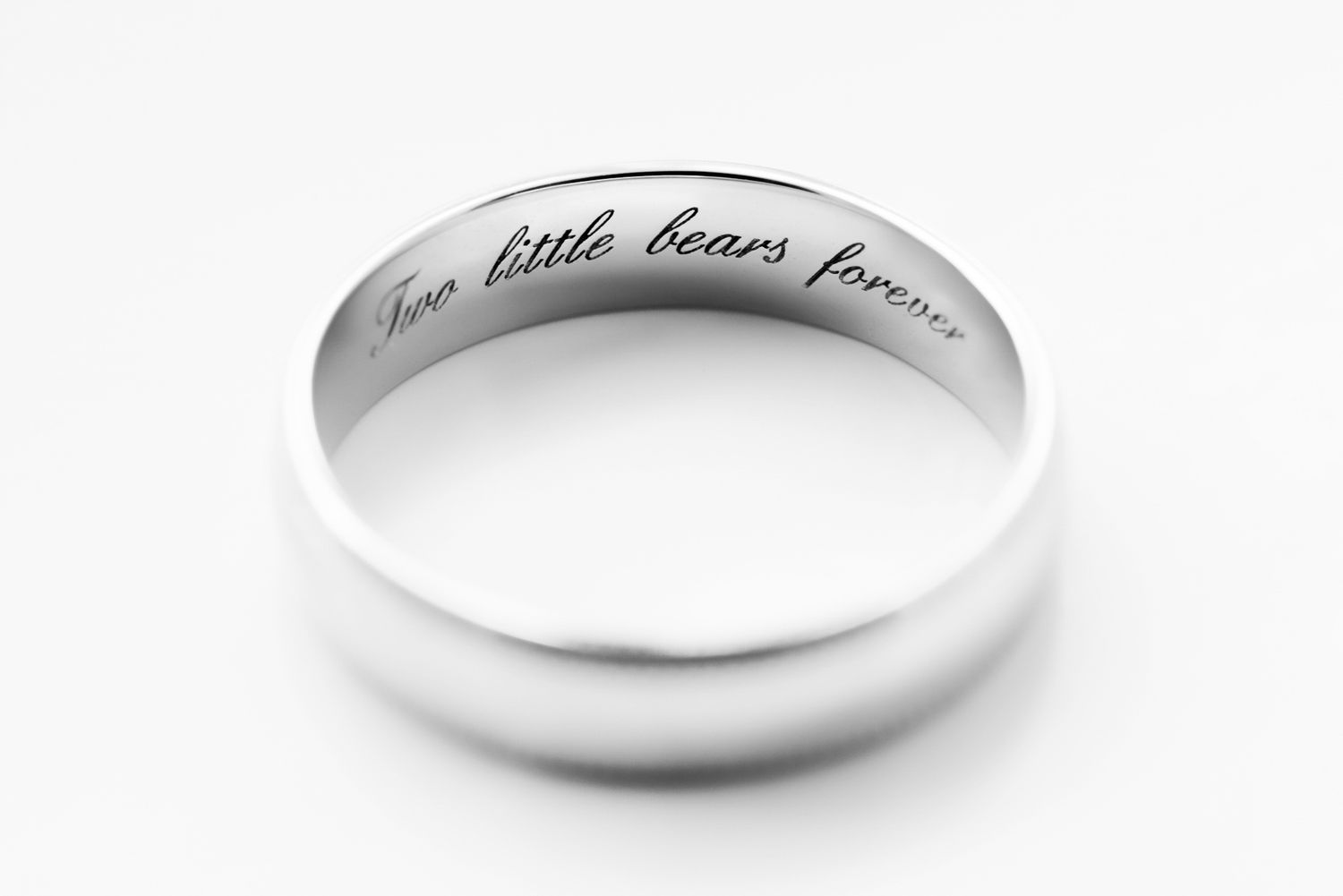 Silver ring with cursive engraving reading 