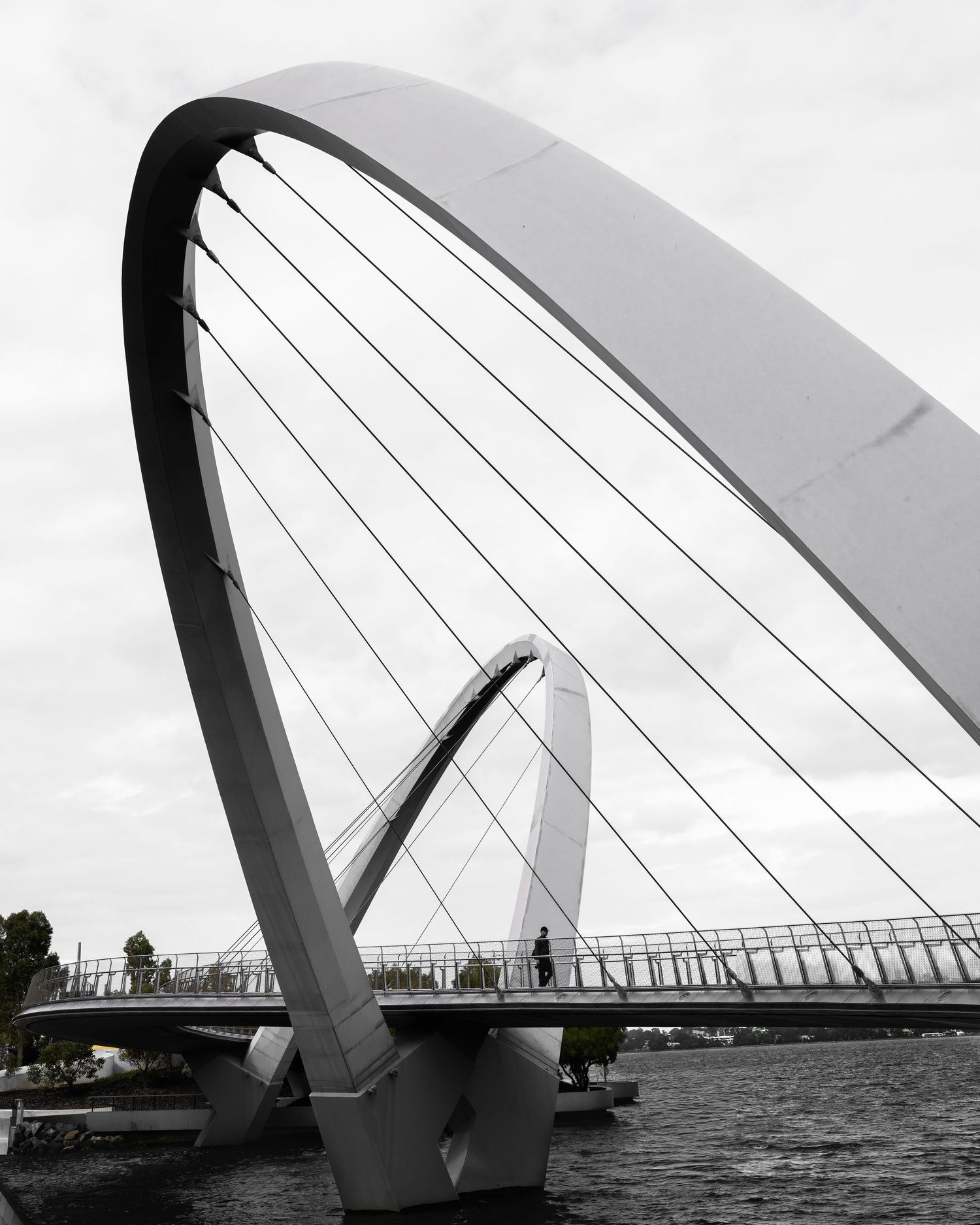 The Lone Figure — black and white architectural photograph featuring a solitary figure beneath the Matagarup Bridge in Perth.
