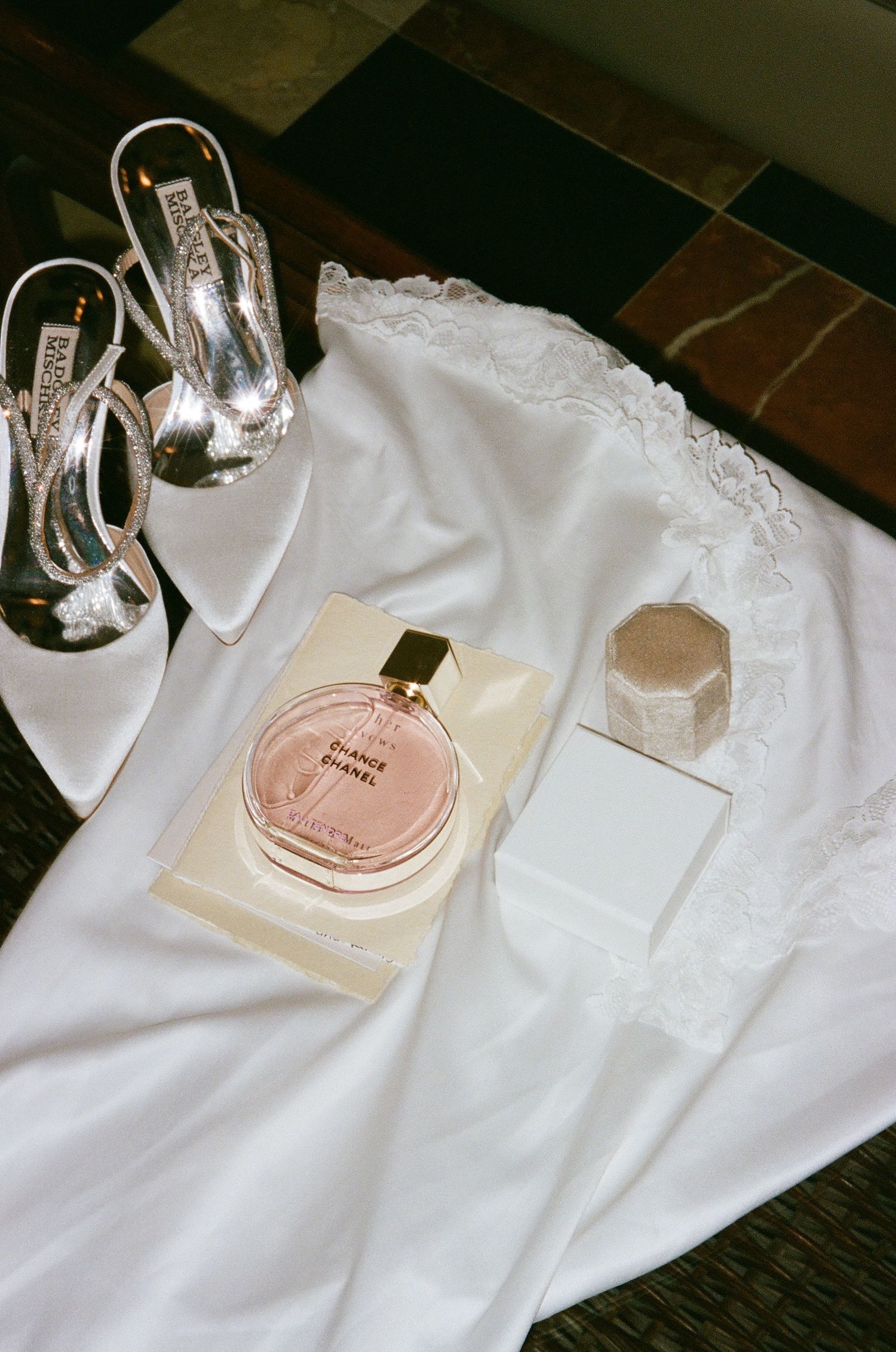 Bridal flat lay including perfume, shoes and ring box