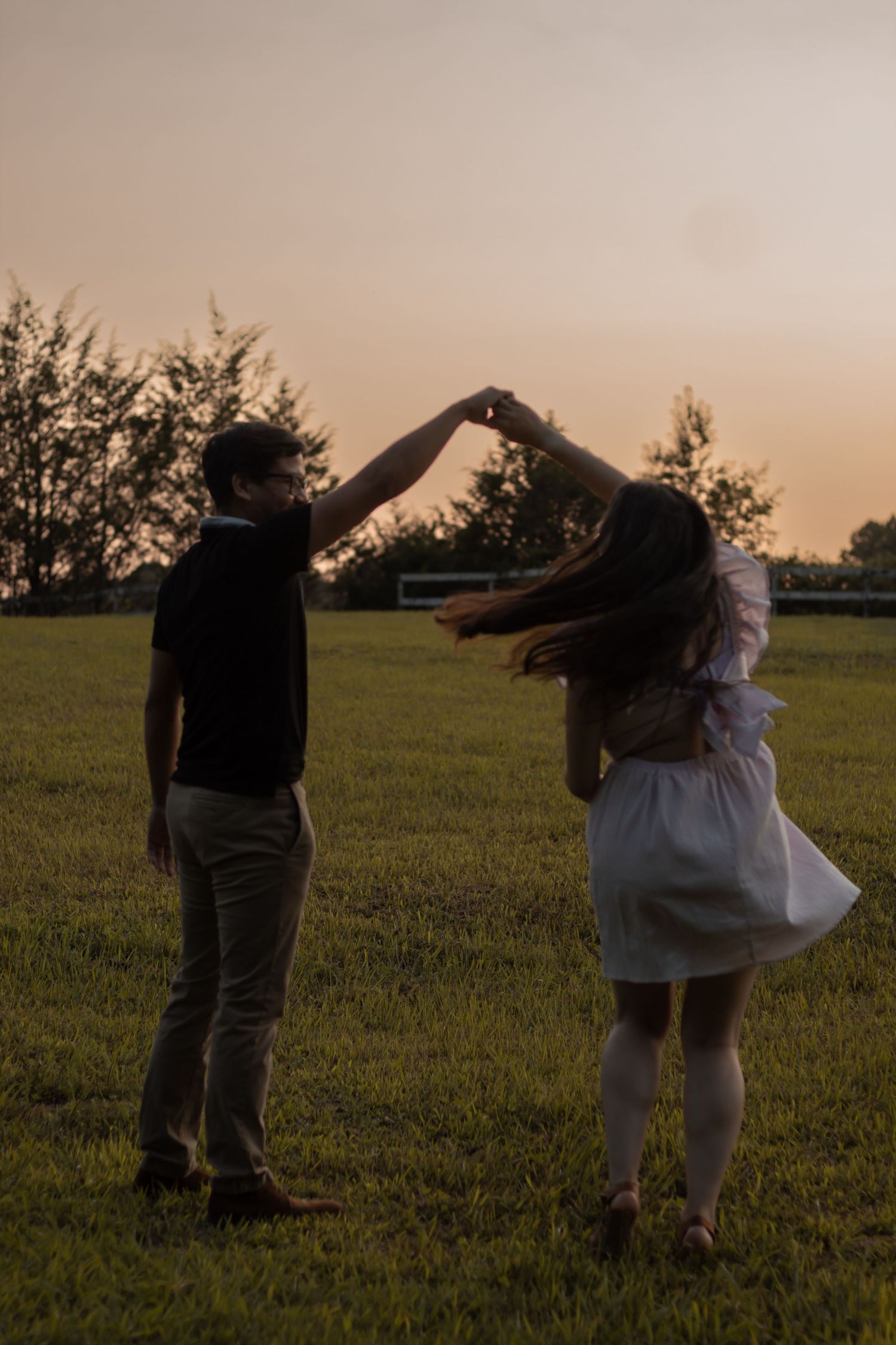 picture of couple, guy twirling girl at sunset.