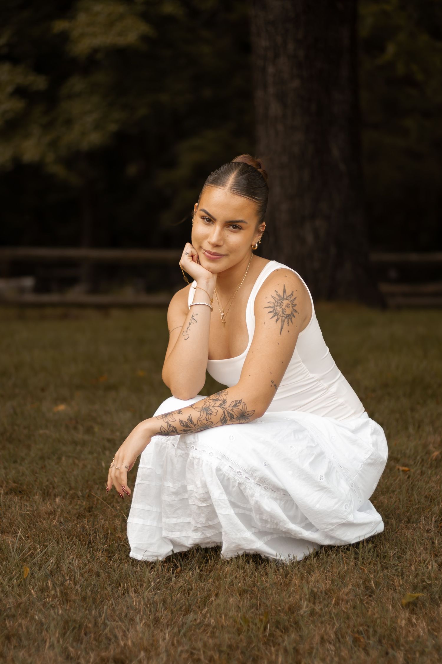 picture of girl in white dress sitting down looking straight.