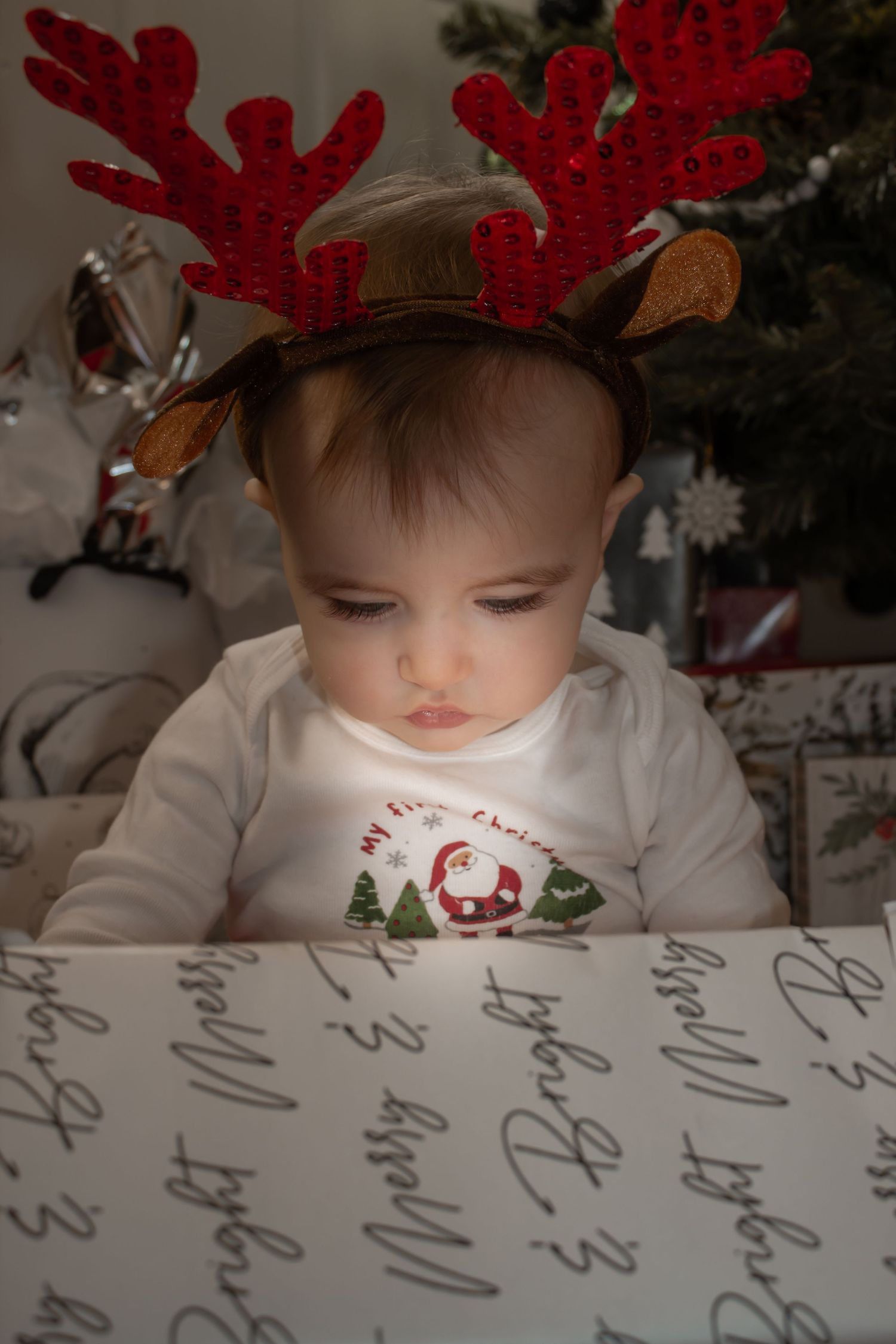 picture of baby looking at present with light shining through.
