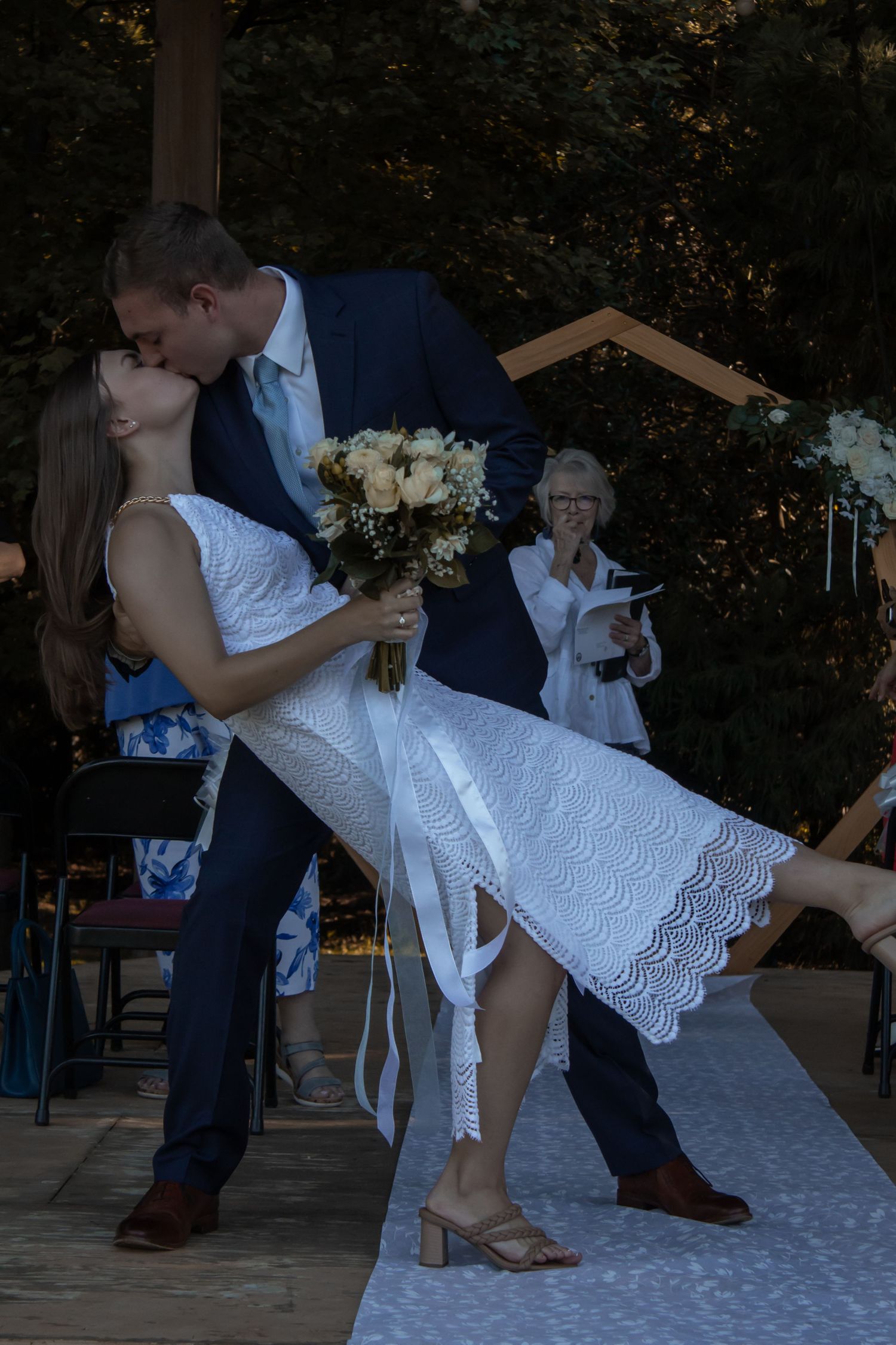 picture of couple kissing at their wedding ceremony after they say, 