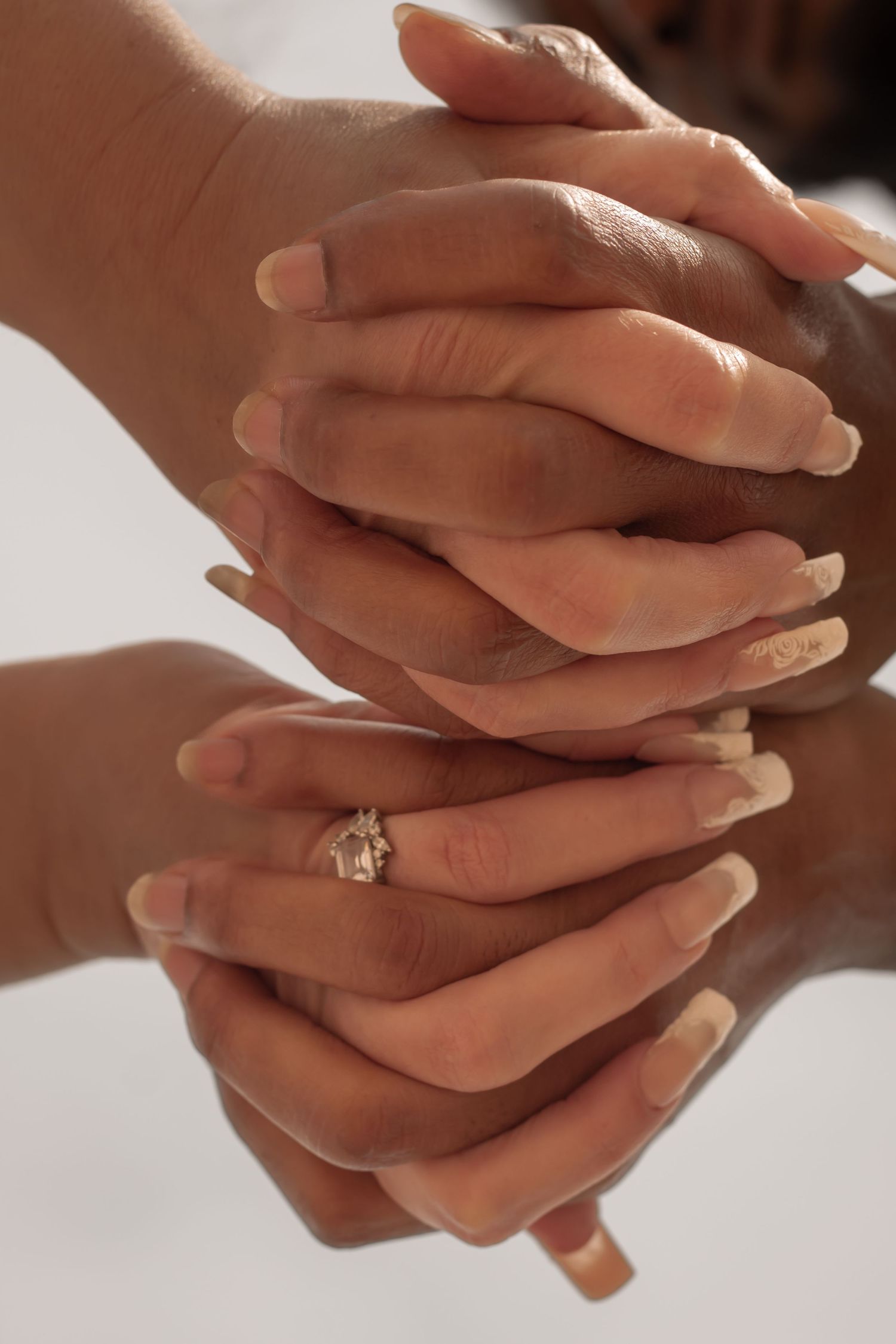 picture of couples hands showcasing engagement ring.