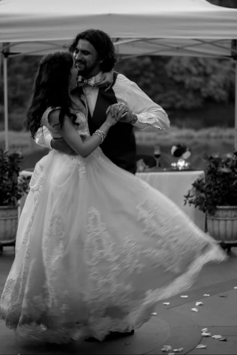 picture of austin andtori on their wedding day, black and white photo. they are holding each other and smiling. candid shot.