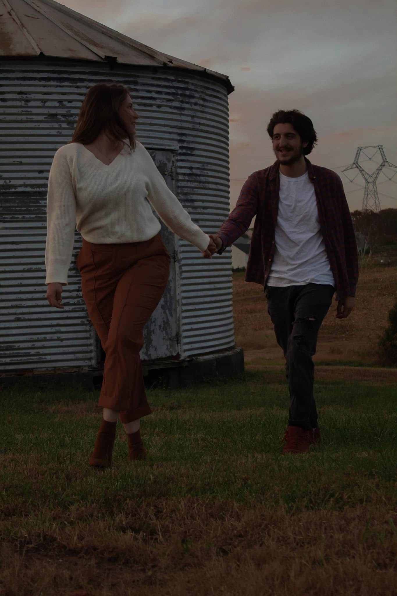 picture of vinny and anna, couple who wrote review for amber dunnigan, couple holding hands. darker tone