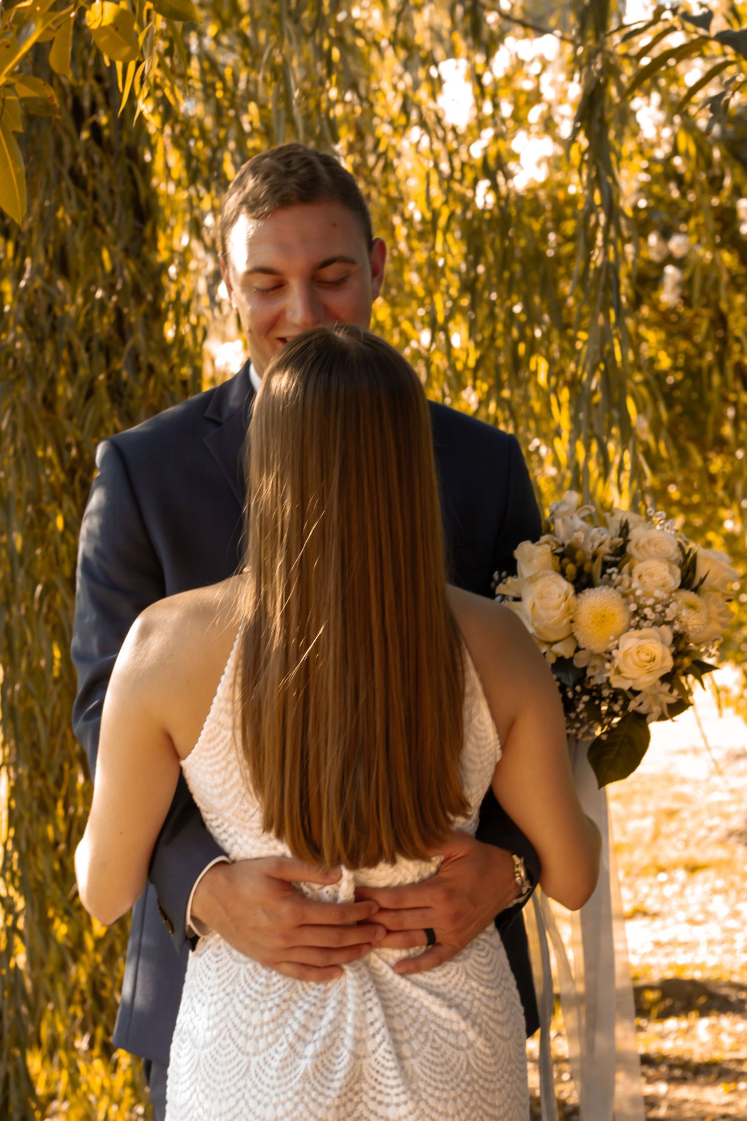picture of couple under the trees, back of girl, she's looking at guy.
