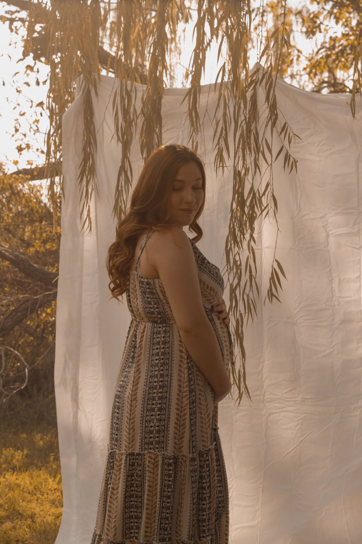 picture of a mom to be. maternity picture, golden hour, sun setting.