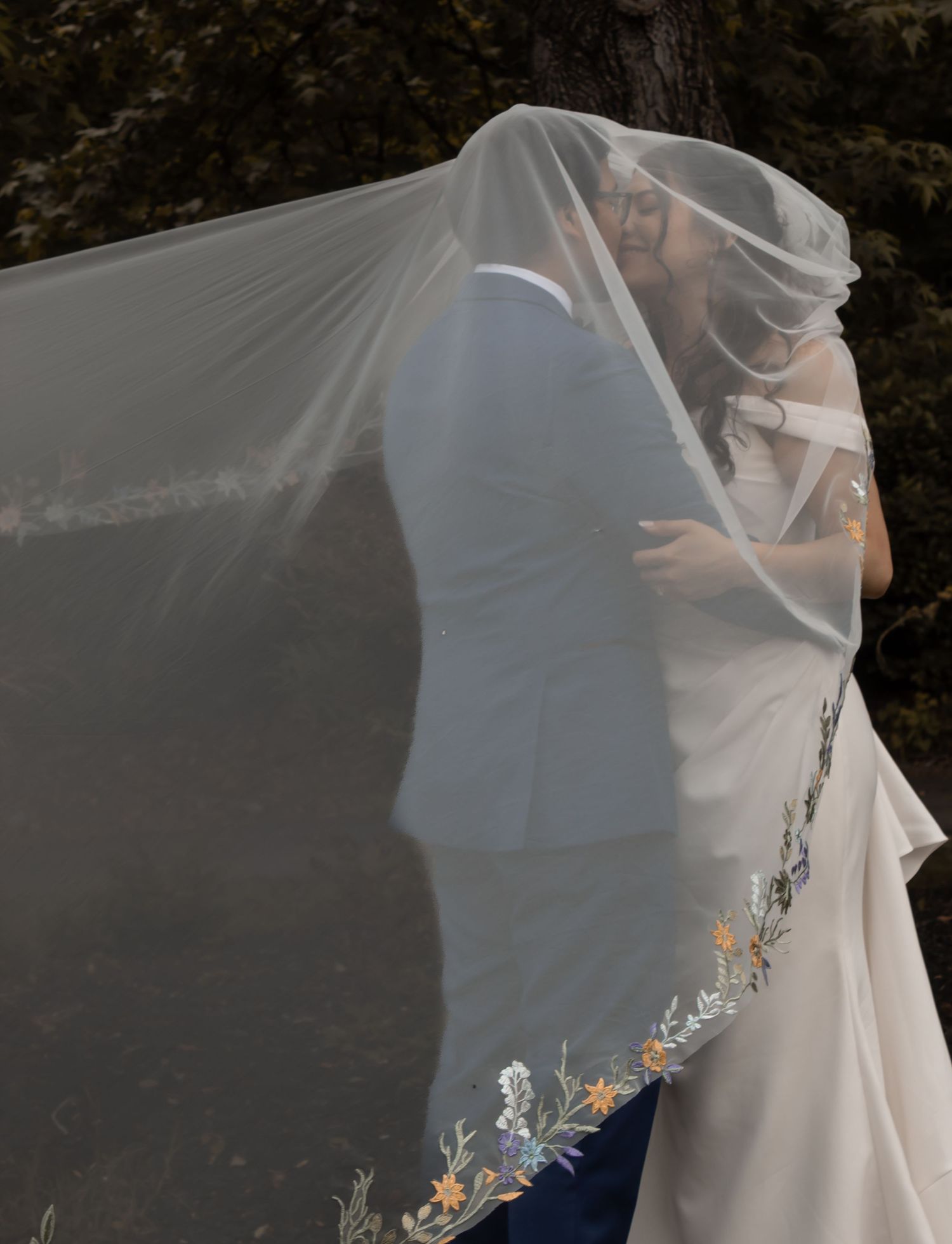 picture of bride and groom kissing underneath her veil