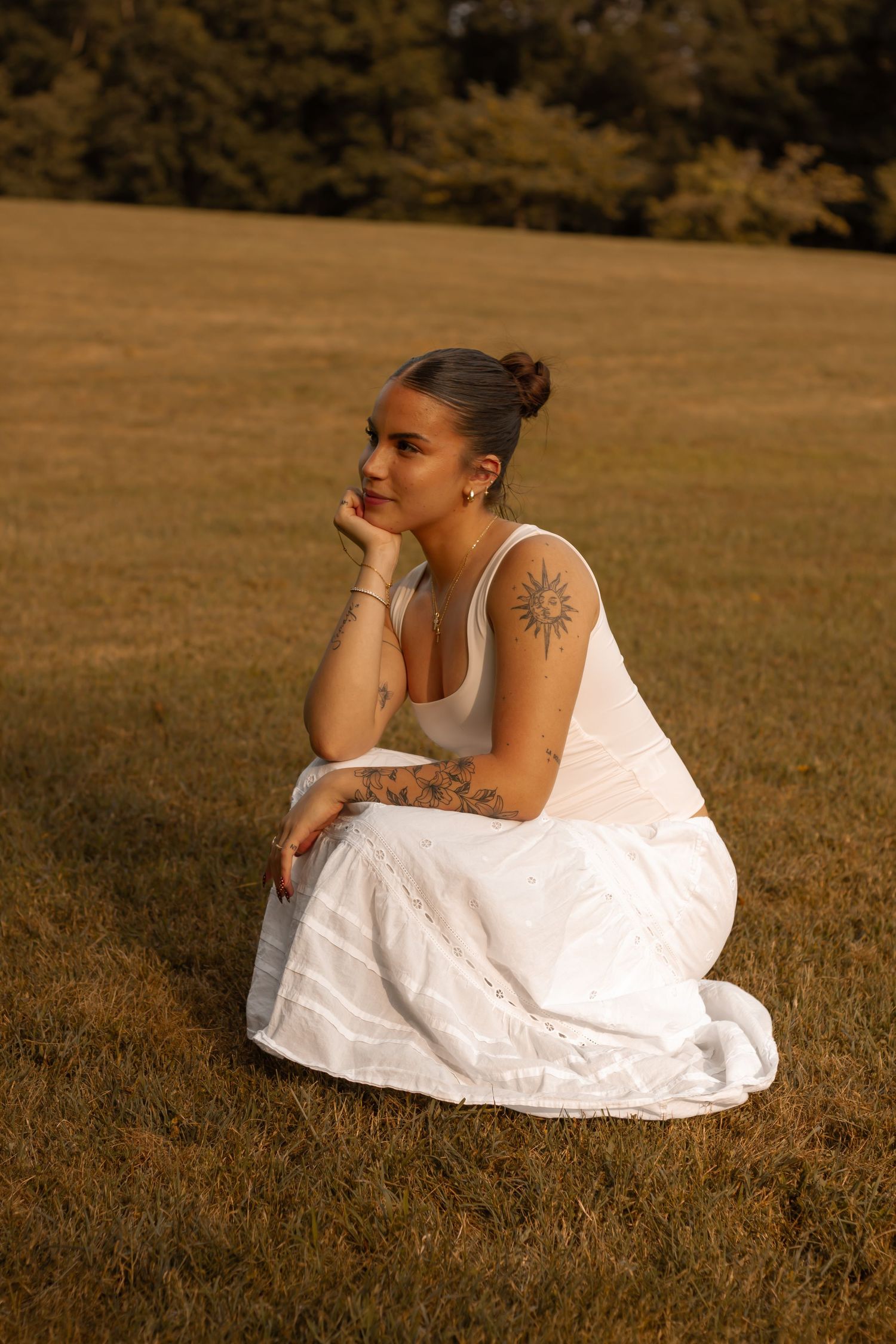 picture of girl sitting down, looking away, golden hour.
