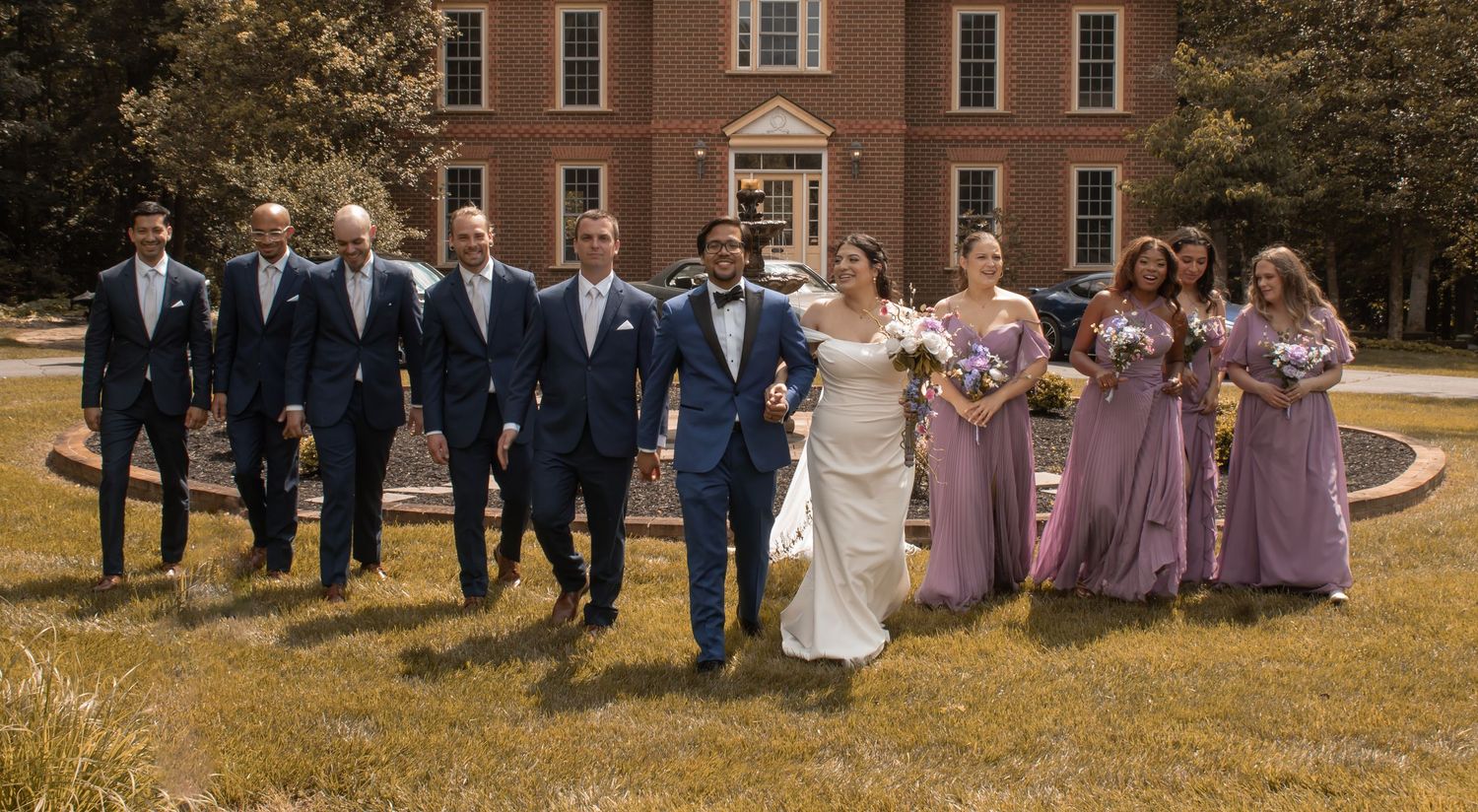 picture of bride and groom and their whole bridal party watching them walking towards the camera