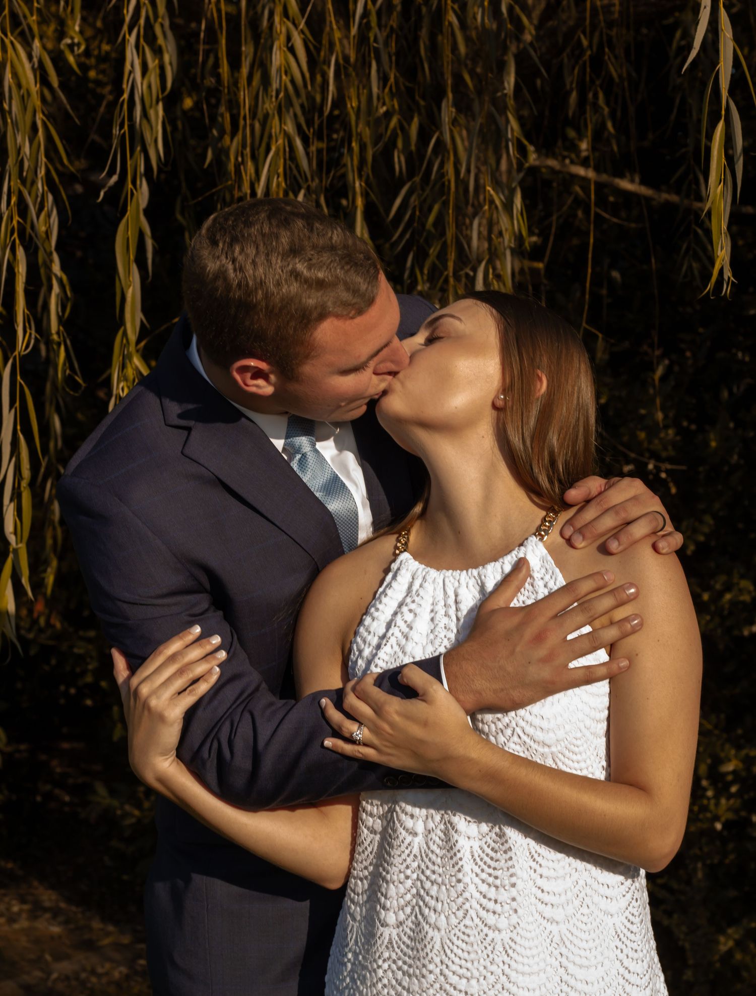 picture of couple kissing under the tree, guy is holding her