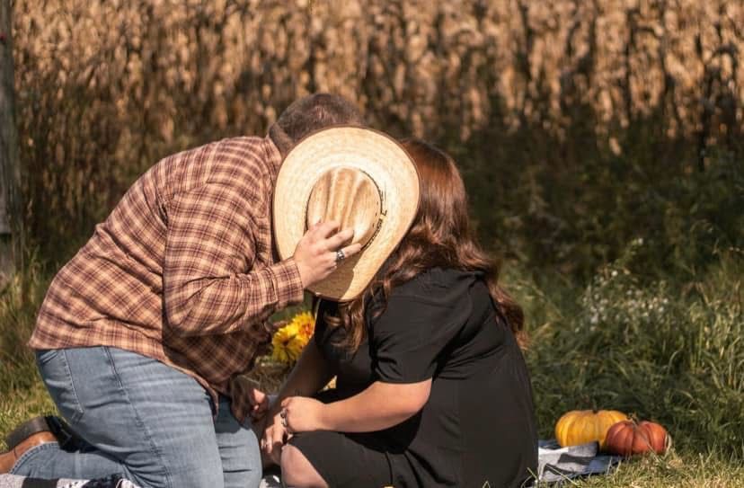 picture of ronnie and megan  who also wrote review for amber dunnigan. couple sitting down with guy holding a straw hat in front of their fa