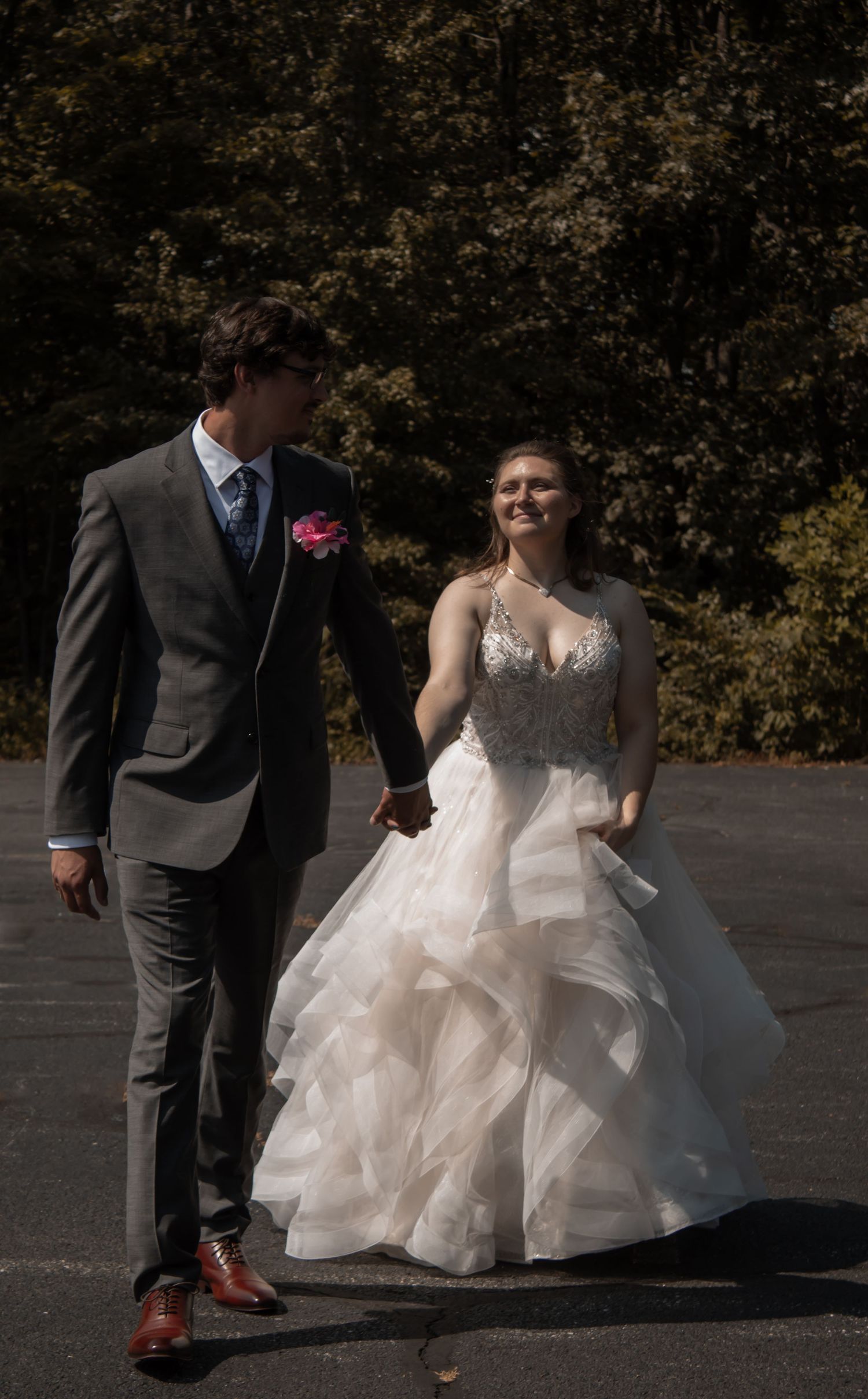 picture of bride and groom walking together in parking lot.