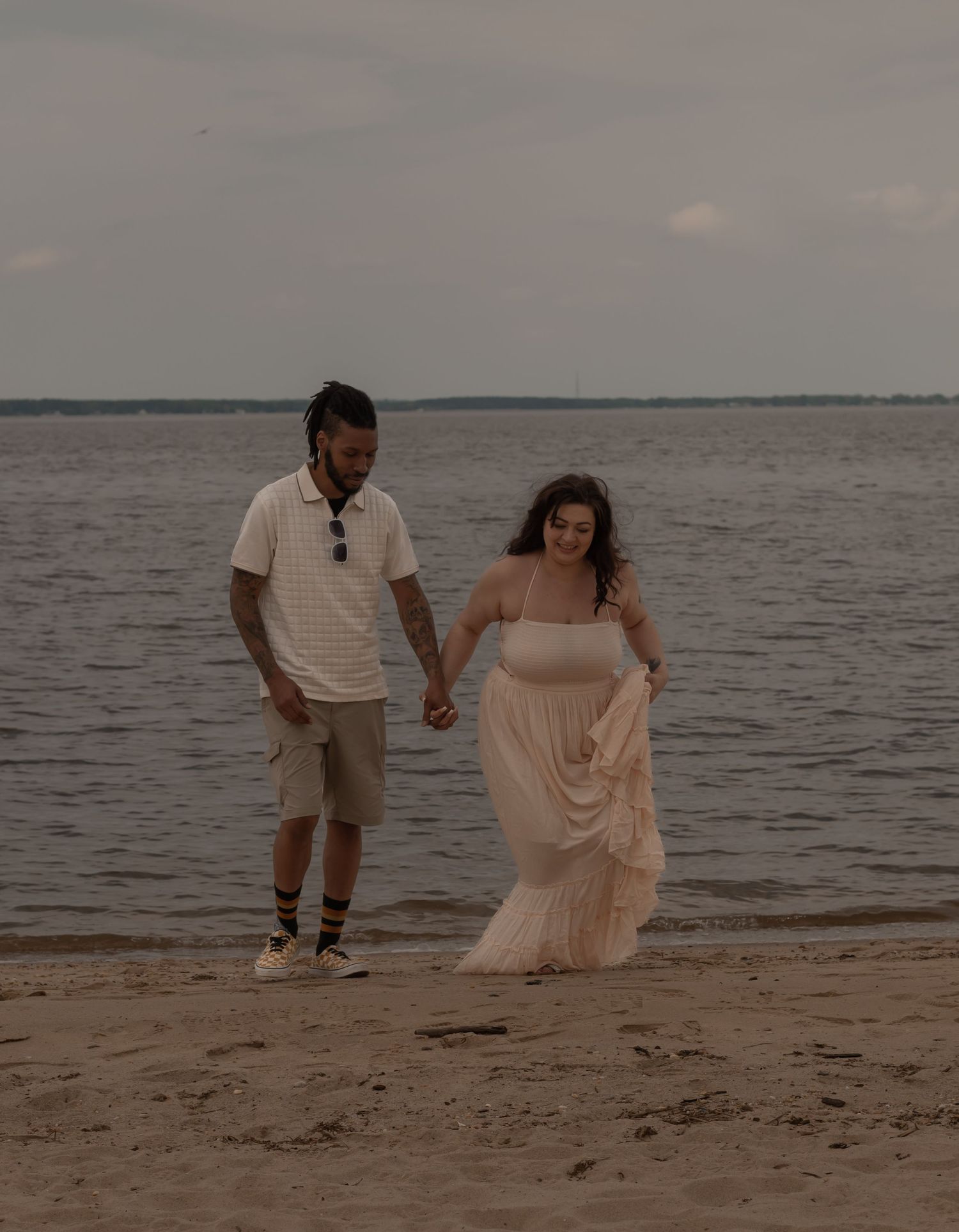 picture of couple at beach, engagement session, they're laughing and having a good time.
