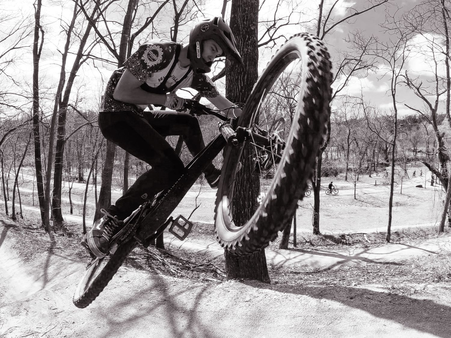 Black and white photo of mountain biker performing aerial trick in winter park.