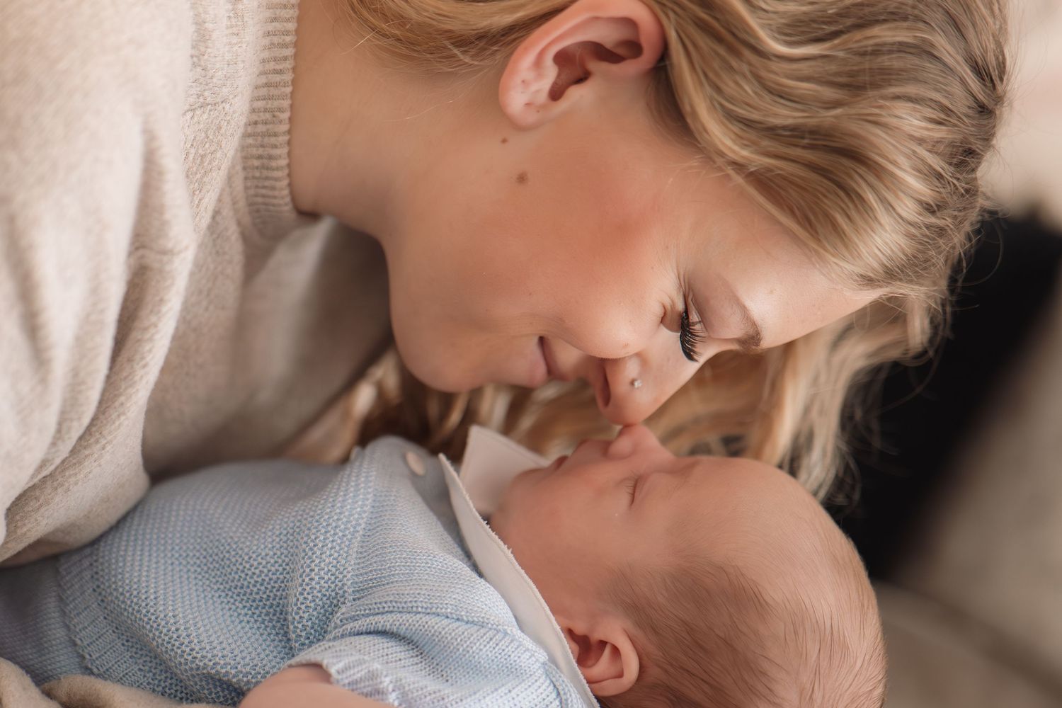 Mother and baby sharing a tender moment during newborn photography session